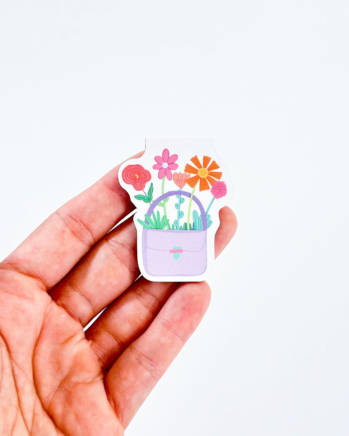 Magnetic bookmark con diseño 'Purse of Flowers', ilustrado con un bolso lleno de flores en tonos vibrantes, creado por Julizco.