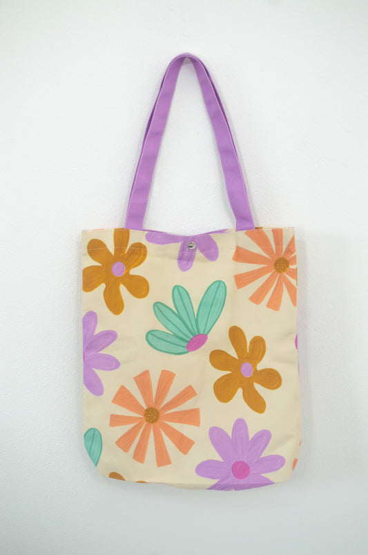 Tote bag Flower Paradise, de tela canvas con un diseño vibrante de flores coloridas, incluye bolsillo interior con zipper y botón, ideal para uso diario y actividades al aire libre, ilustración exclusiva de Julizco