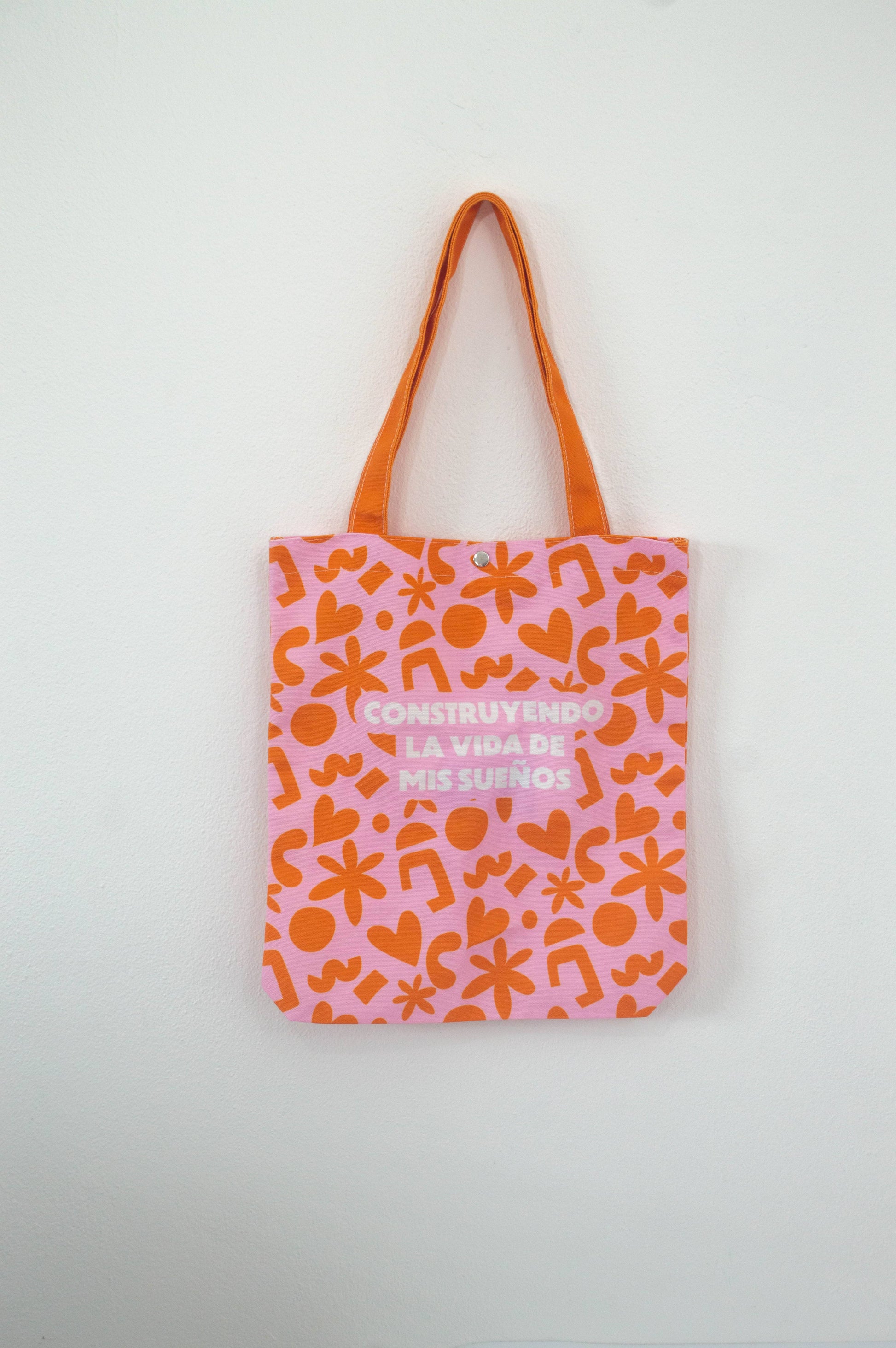 Tote bag Construyendo La Vida de Mis Sueños (Groovie Cutie), de tela canvas con un diseño colorido y divertido, incluye bolsillo interior con zipper y botón, ideal para uso diario y actividades al aire libre, ilustración exclusiva de Julizco