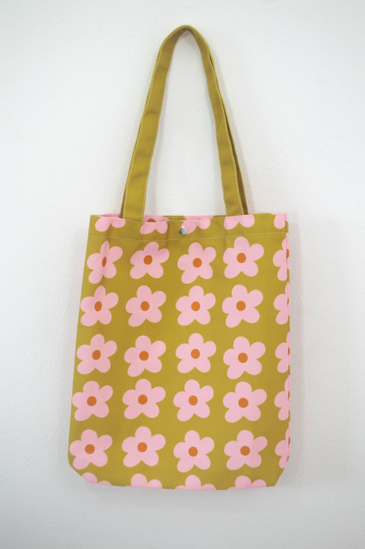 Tote bag Olive & Pink Flowers, de tela canvas con un diseño vibrante de flores en tonos oliva y rosa, incluye bolsillo interior con zipper y botón, ideal para uso diario y actividades al aire libre, ilustración exclusiva de Julizco