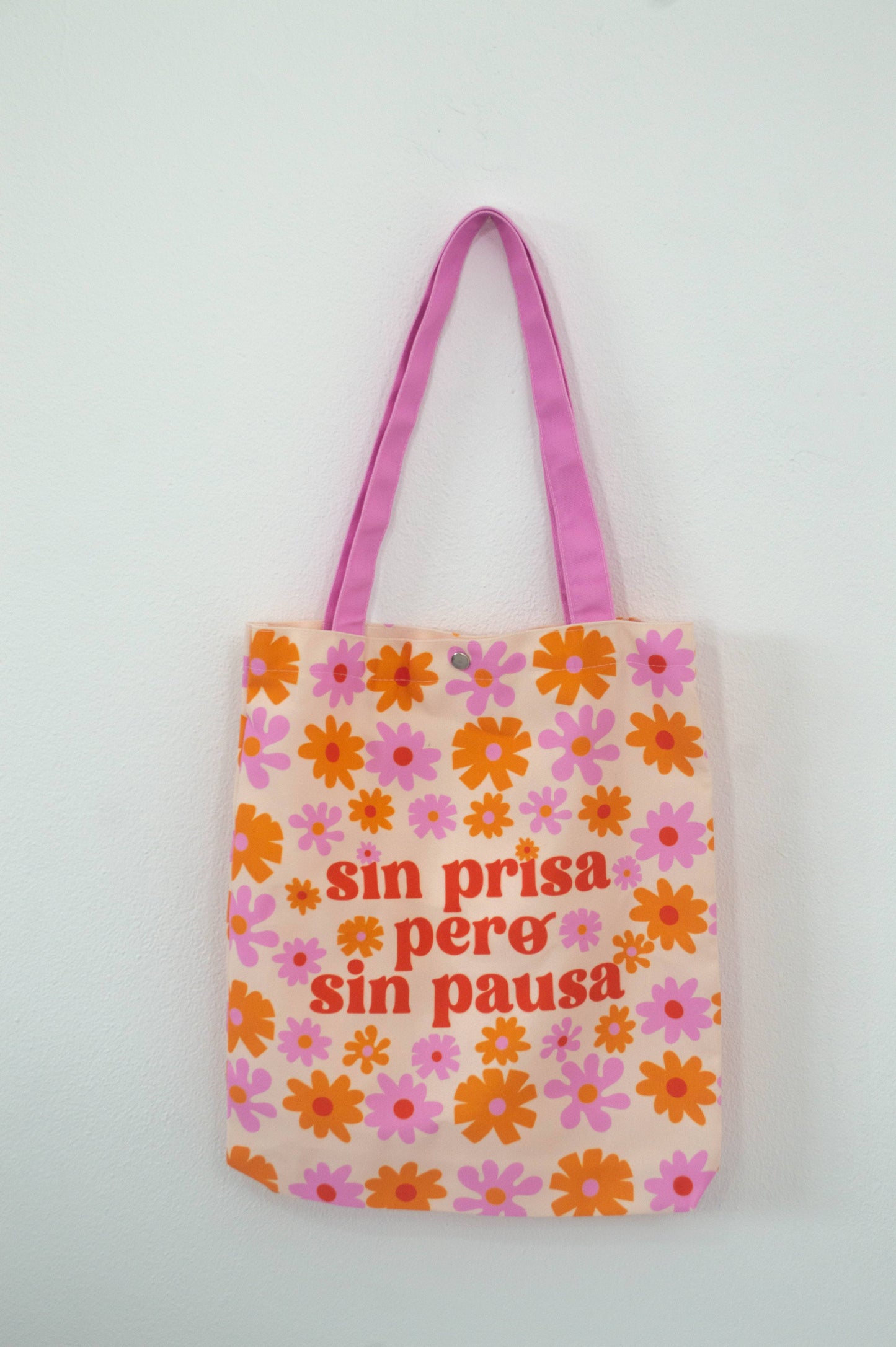 Tote bag Sin Prisa Pero Sin Pausa, de tela canvas con un diseño floral encantador, incluye bolsillo interior con zipper y botón, ideal para uso diario y actividades al aire libre, ilustración exclusiva de Julizco