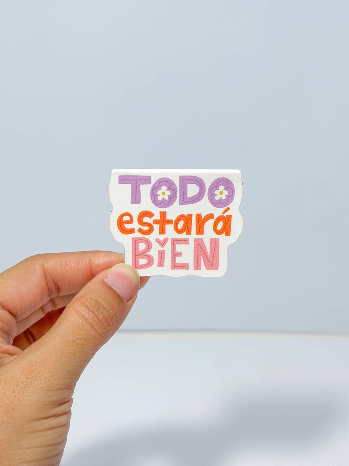 Magnetic bookmark con diseño 'Todo Estará Bien', ilustrado con colores suaves y tipografía relajante, rodeado de elementos florales, creado por Julizco.