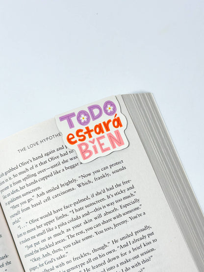 Magnetic bookmark con diseño 'Todo Estará Bien', ilustrado con colores suaves y tipografía relajante, rodeado de elementos florales, creado por Julizco.
