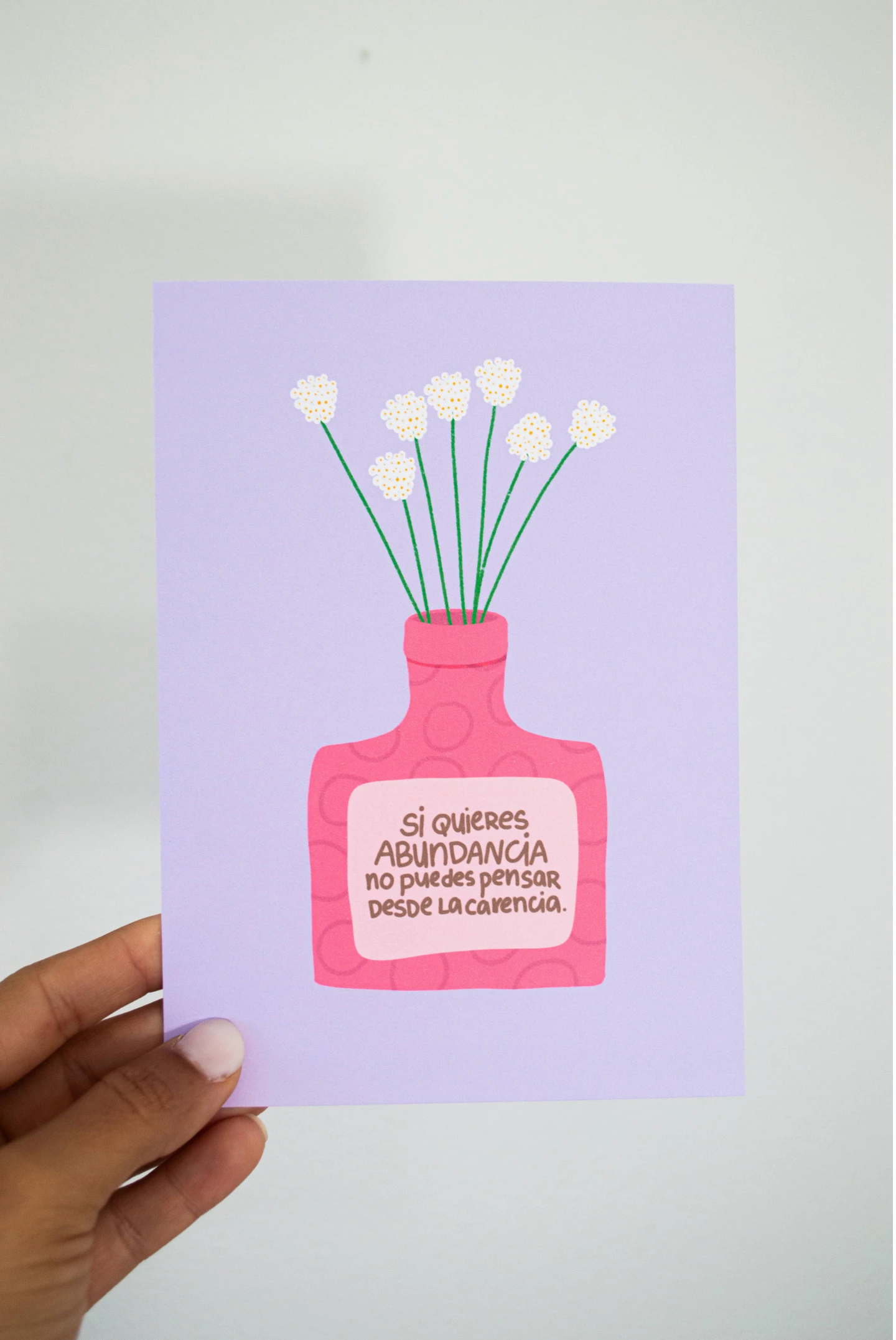 Ilustración de un frasco rosa lleno de flores con la frase: "Si quieres abundancia no puedes pensar desde la carencia", ideal para inspirar una mentalidad positiva.